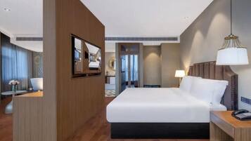 Een hotelkamer met een bed, een bureau, een stoel, een televisie en een lamp.