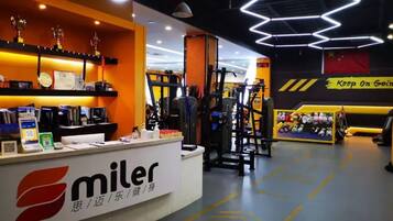 A gym with exercise equipment, a reception desk, and motivational signage.