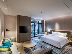 A modern hotel room with a large bed, a sofa, a small round table, and a TV. - Lebanshan Hotel Chongqing (Chongqing)
