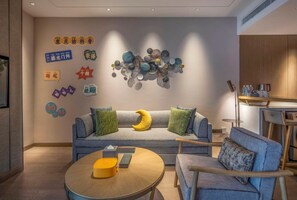 A modern living room with a sofa, armchairs, a coffee table, and a wall art installation. - Lebanshan Hotel Chongqing (Chongqing)