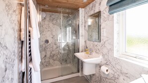 A bathroom with a glass-enclosed shower, a white sink, and a marble wall. - The Buchanan - sleeps 6 guests  in 3 bedrooms with hot tub - 5 star award winning lodges (Lauder)