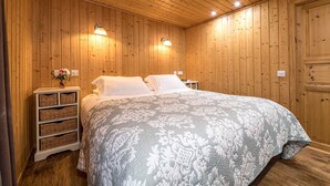 A wooden-paneled bedroom with a large bed, two bedside tables, and wall-mounted lamps. - The Buchanan - sleeps 6 guests  in 3 bedrooms with hot tub - 5 star award winning lodges (Lauder)