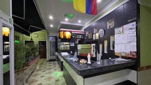 A reception area with a counter, a television, and a wall with various notices. - HOTEL DON JUAN  (Guadalajara de Buga)