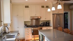 Una cocina moderna con armarios blancos, electrodomésticos de acero inoxidable y una isla grande.