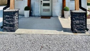 A cylindrical metal building with a wooden porch and a 'GSI' sign. - The Silo - Unique Experience, Lake, Firepit, BBQ (vian)
