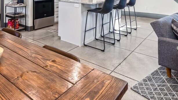 A modern kitchen with white cabinets, a central island with bar stools, a stainless steel refrigerator, and a microwave. - The Silo - Unique Experience, Lake, Firepit, BBQ (vian)