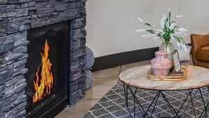 A modern living room with a stone fireplace, a flat-screen TV mounted above it, and a neon sign reading "The Sl". - The Silo - Unique Experience, Lake, Firepit, BBQ (vian)