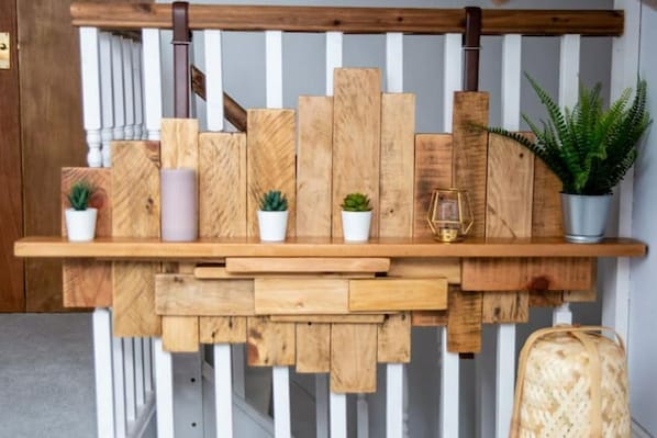 Simple, functional shelf with potted plants and decorative accents.