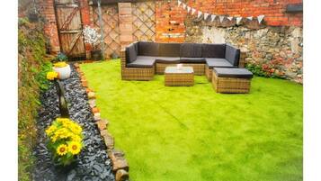 Relax in a serene outdoor seating area with a comfortable sofa and ottomans.