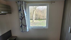 Una habitación con ventana, cortina y puerta.