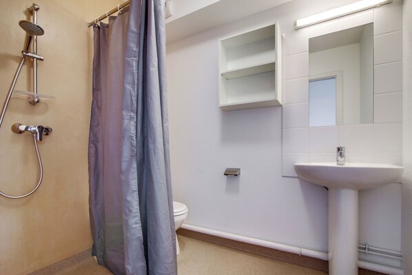 Un baño con ducha, inodoro y lavamanos.