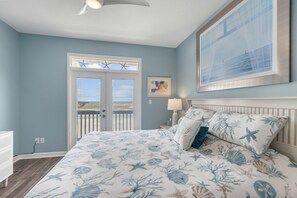 Une chambre à coucher avec un lit, une table de chevet, une fenêtre et une porte.