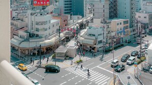 A cityscape with modern buildings, a prominent tower, and a busy intersection. - Staypia Condominium Namba Ebisu (Osaka)