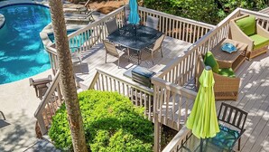 Eine Terrasse mit Pool, Gartenmöbeln und einer Pergola.