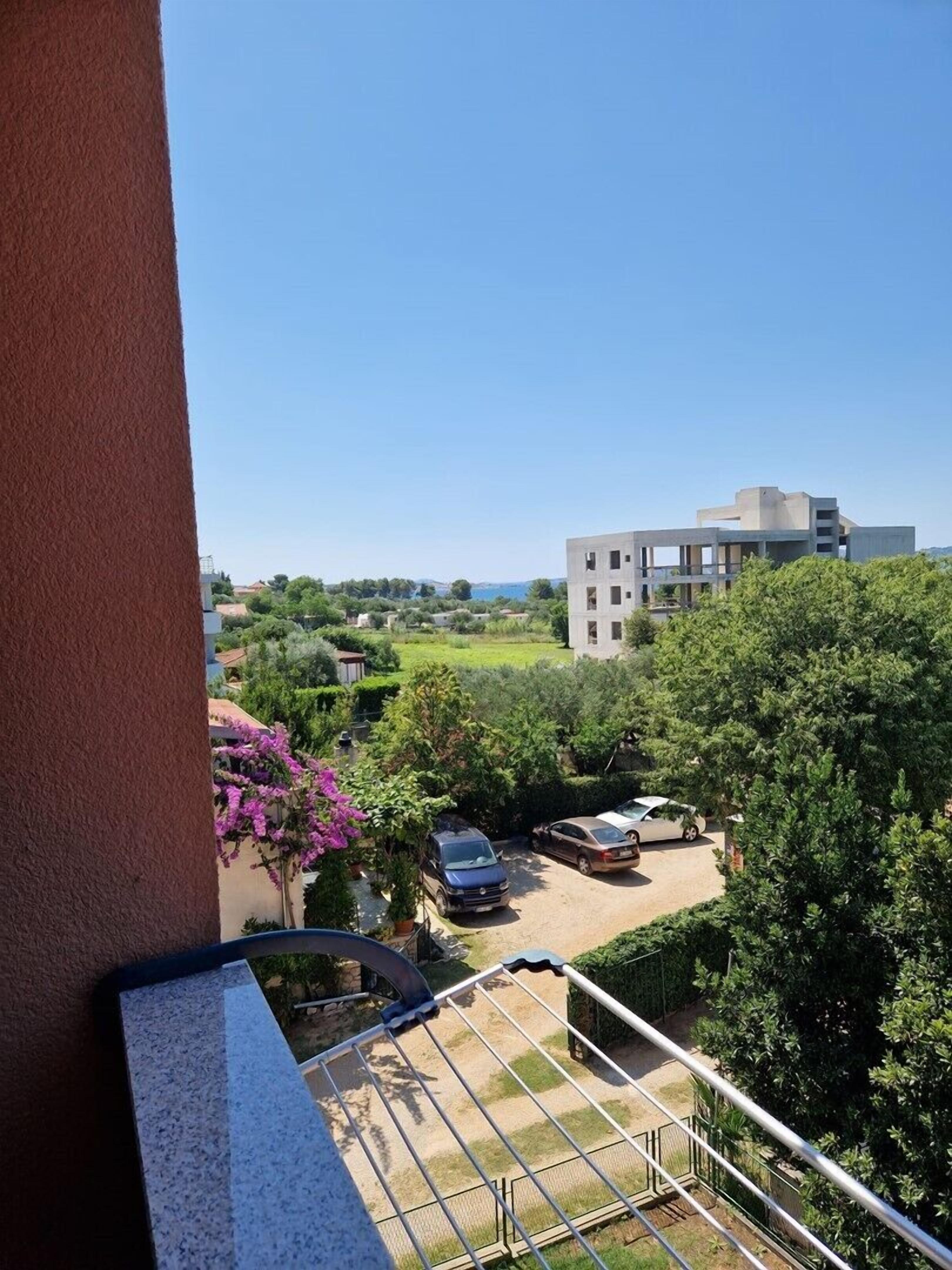 A balcony overlooking a courtyard with a building in the background.