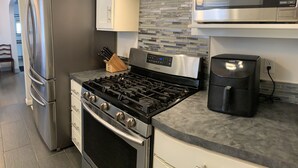 A modern kitchen with stainless steel appliances, a gas stove, and a coffee maker. - Garland Charmer (Spokane)