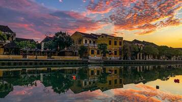 A reflection of buildings and a body of water during sunset.