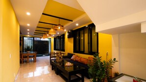 A modern living room with a sofa, coffee table, and dining area. - Hoi An Town Center (Da Nang)