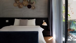 A hotel room with a bed, a nightstand, a lamp, and a view of the outside balcony. - Hoi An Town Center (Da Nang)