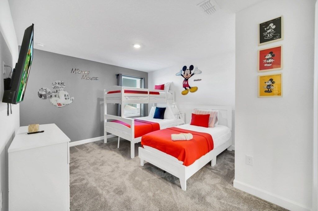 A child's bedroom with bunk beds, a TV, and wall decorations.
