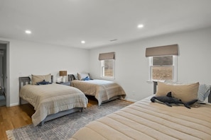 A bedroom with two single beds, a large bed, and a window with a view. - Private Pickleball Court, Walk to Hen Cove (Bourne)