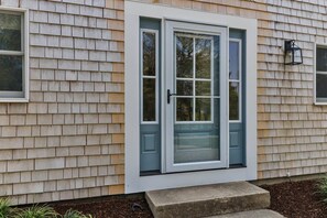 A house with a front door, a window, and a small step leading to the door.