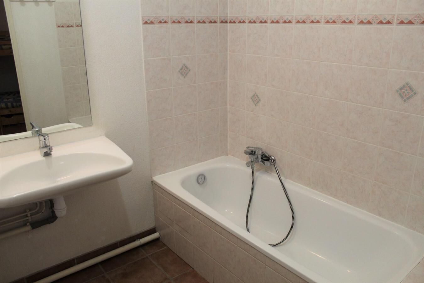 Ein Badezimmer mit Waschbecken, Badewanne und Spiegel.