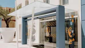 A modern building with a glass storefront and a covered seating area. - Biancodonda Greenblu Hotel & SPA (Gallipoli)