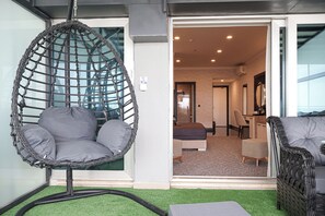 A room with a hanging chair, a sofa, and a bed.