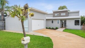 A two-story house with a garage, a front yard, and a mailbox. - Seaworthy Sanctuary • Stylish Coastal Escape (Jan Juc)