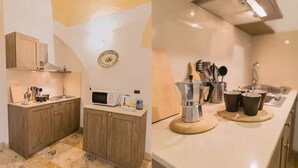 A modern kitchen with wooden cabinets, a microwave, a coffee maker, and a sink. - [Sassi-Suite]- Aura - Matera (Milano)