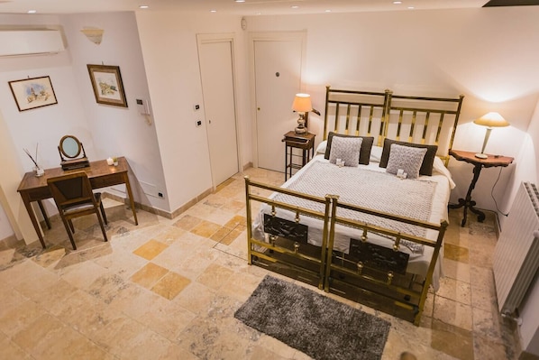 A bedroom with a bed, bedside tables, a desk, and a chair.