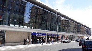 Un edificio moderno con fachada de vidrio y un letrero azul que dice "Bari Centrale".