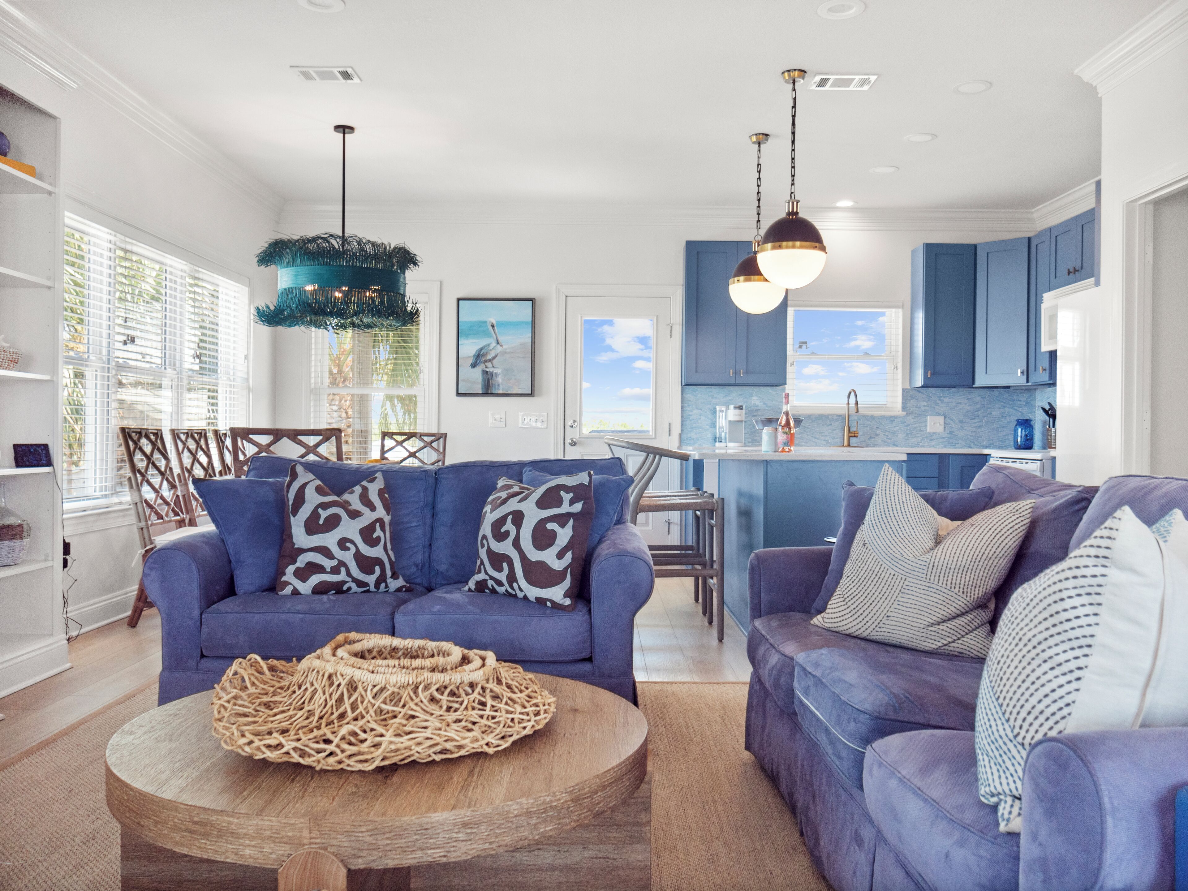 Een moderne woonkamer met twee banken, een salontafel en een eethoek met stoelen.