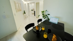 Ett modernt matområde med ett bord dukat för frukost, inklusive croissanter och apelsinjuice.