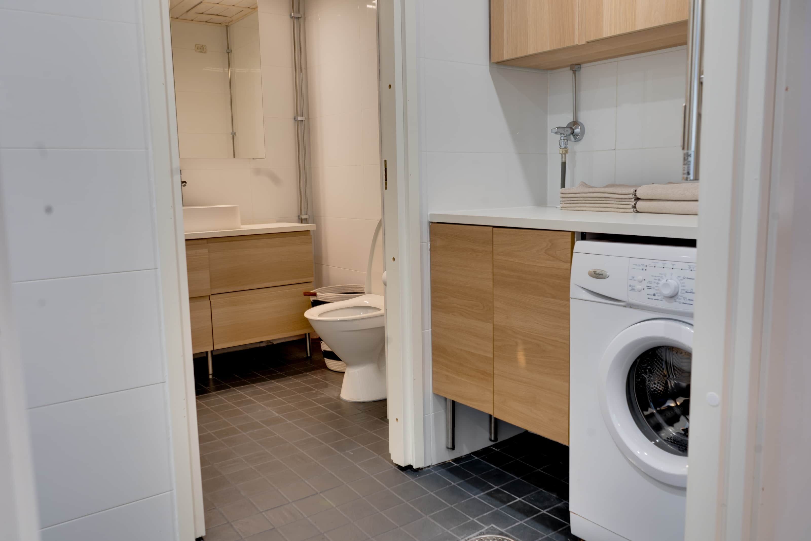 Un baño moderno con inodoro, lavamanos y lavadora.
