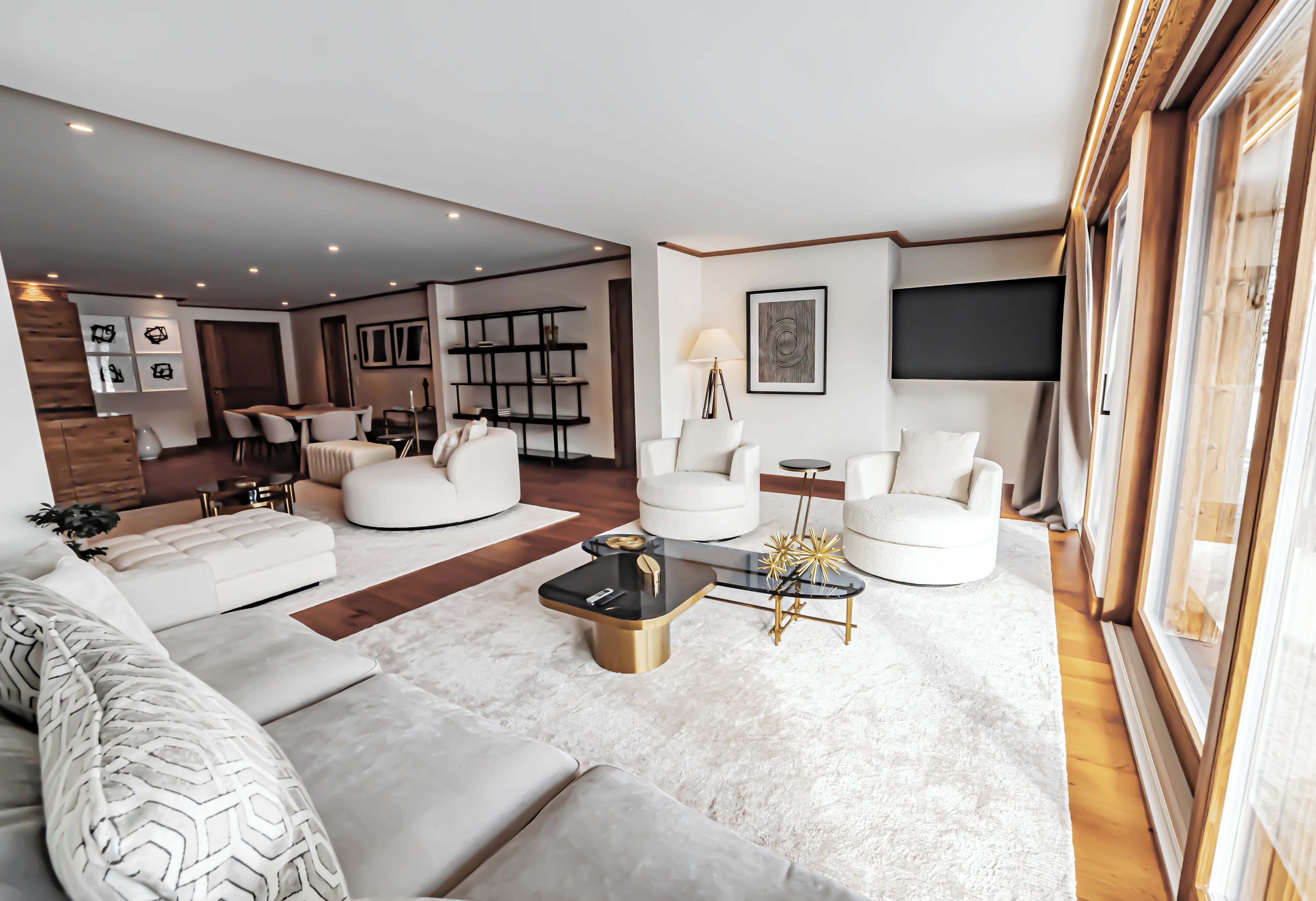Ein modernes Wohnzimmer mit einer Couch, Sesseln, einem Couchtisch und einem Bücherregal.