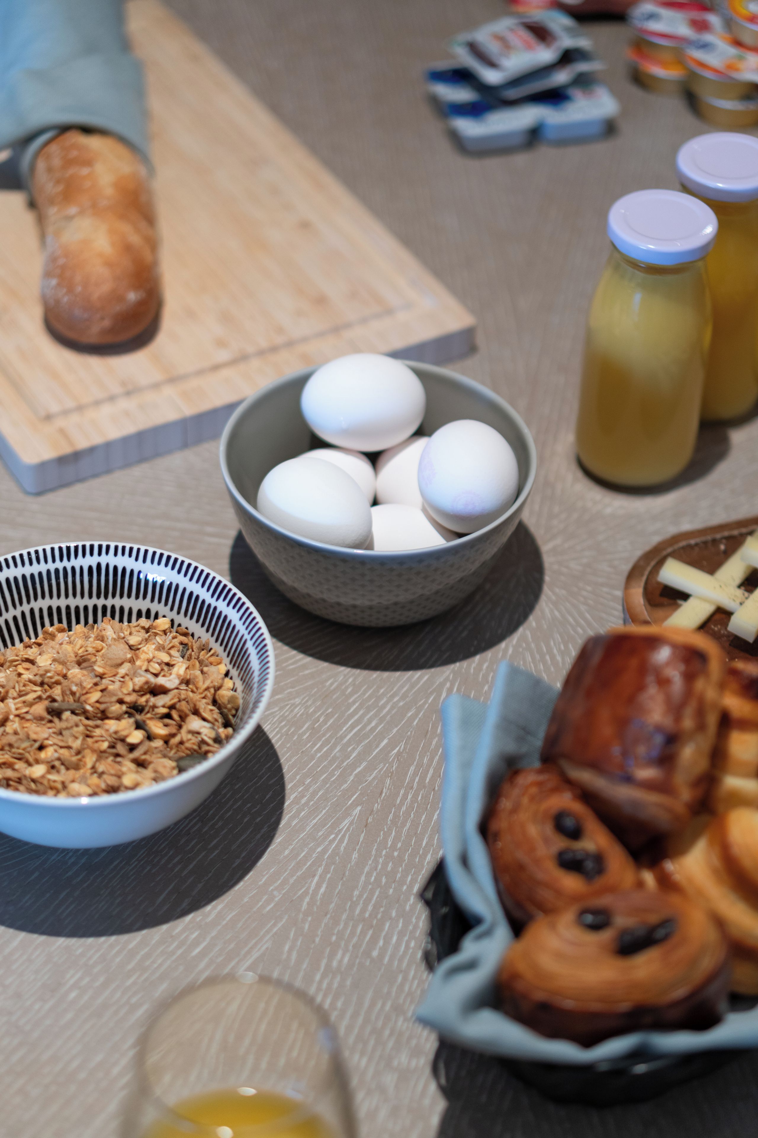 A breakfast table with eggs, bread, and various breakfast items.