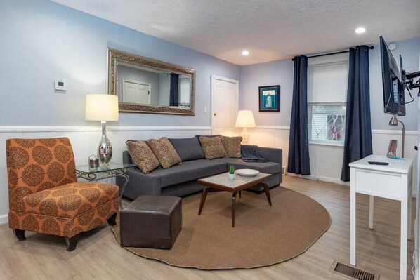 A living room with a sofa, armchair, coffee table, and lamps.