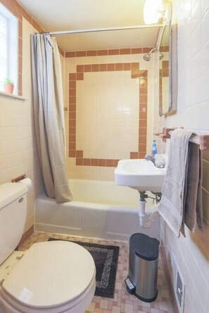 A bathroom with a toilet, sink, and bathtub.
