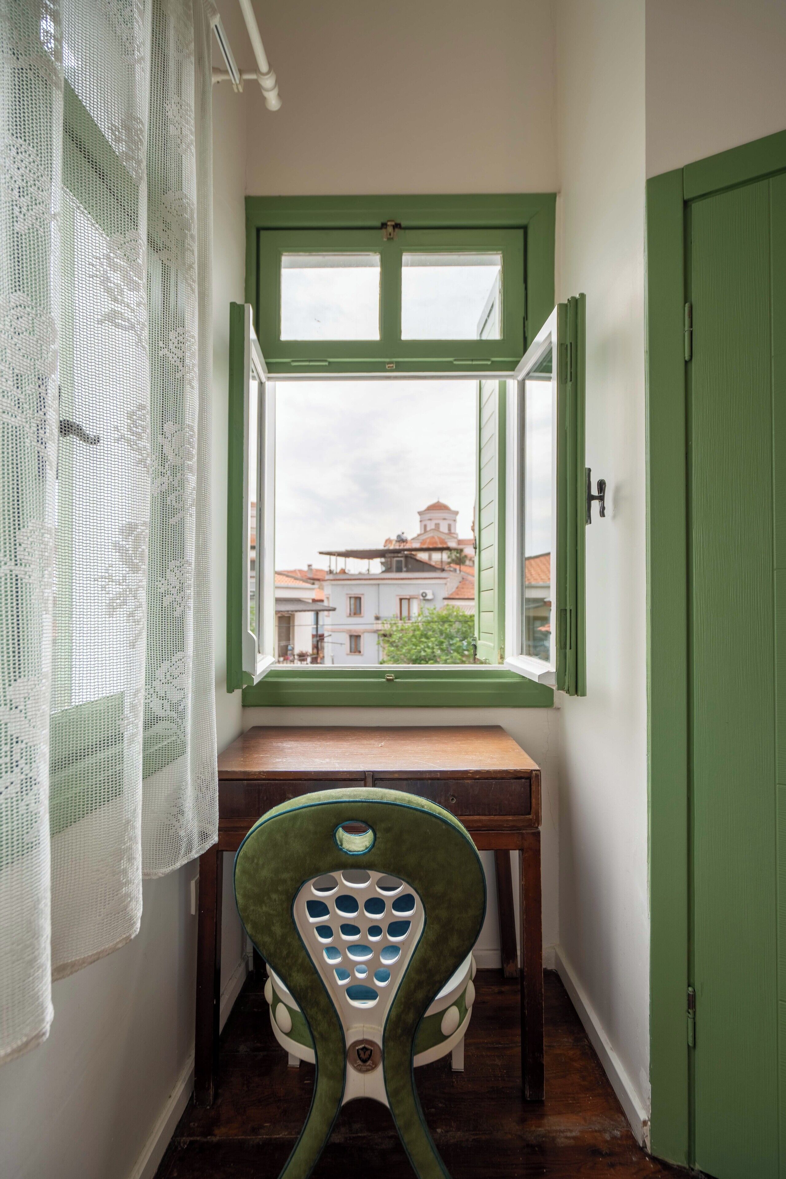 A narrow room with a window, a desk, and a chair.