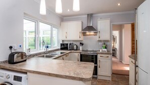 A modern kitchen with a central island, built-in appliances, and pendant lighting.