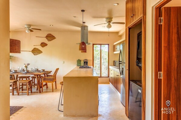 A modern kitchen with a central island, wooden cabinets, and a built-in oven.