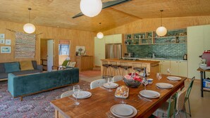 Una cocina moderna con armarios de madera, una isla central e iluminación colgante.
