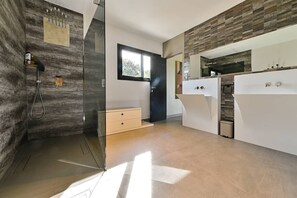 Un baño moderno con ducha, inodoro y lavamanos.