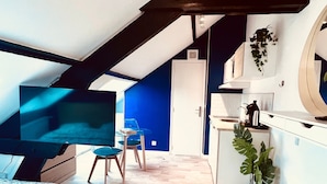 A bedroom with a bed, a TV, a desk, and a chair.