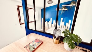 A room with a wooden table, a book, a lamp, and a potted plant. - Tour du monde en 80 jours - Studio avec Terrasse (Amiens)