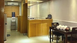 Una cocina moderna con armarios de madera, una zona de comedor con mesa y sillas, y una isla integrada con un fregadero.