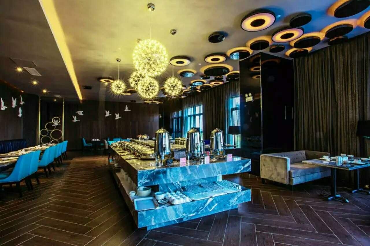Un área de comedor moderna con una encimera de mármol, sillas azules y una disposición escalonada.