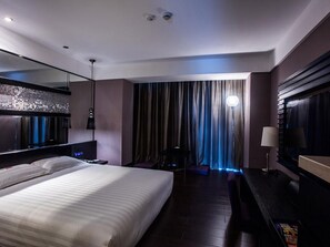 A modern hotel room with a large bed, a desk, a mirror, and a view of the city through curtains. - Crystal Orange Hotel Changzhou Dinosaurs Park (Changzhou)